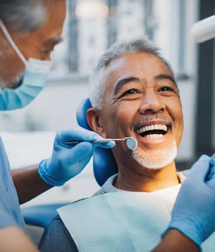 Mature, gray-haired man undergoing dental examination