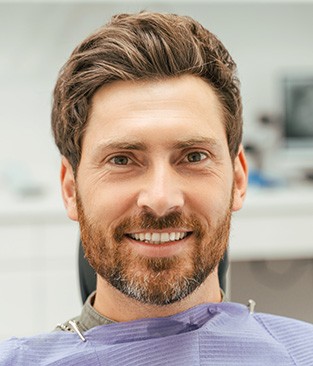 Man sitting in dental chair and smiling