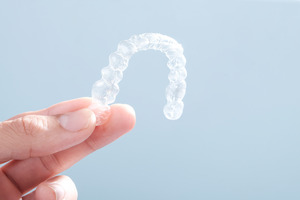 Close-up of holding a single Invisalign aligner