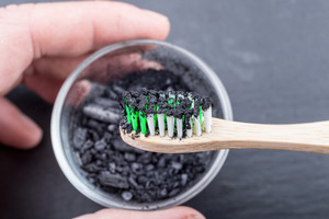 Charcoal on toothbrush for a DIY whitening treatment